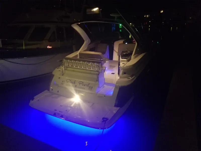 Slide: The Image of 2013 Regal 35 Express Cruiser with blue underwater lights at night. - 8