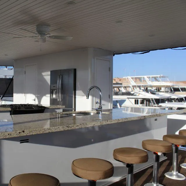 Slide: The Image of Modern kitchen area on 2013 Bravada Houseboat Apollo Trip #7 with granite countertops and bar stools. - 2