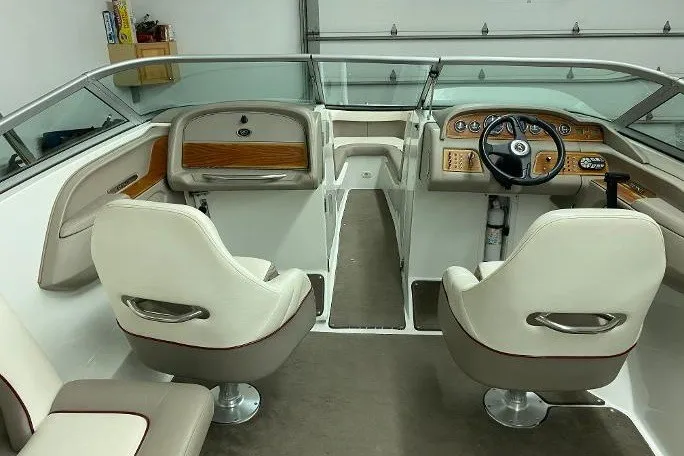 Slide: The Image of Interior of a 2000 Cobalt 246 boat with white seats and wooden dashboard. - 14