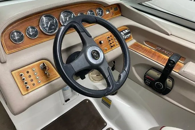 Slide: The Image of Steering wheel and dashboard of a 2000 Cobalt 246 boat with wood accents. - 5