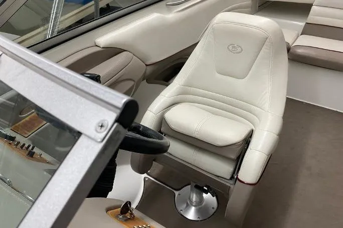 Slide: The Image of Captain's seat of a 2000 Cobalt 246 boat, featuring white upholstery and steering wheel. - 10