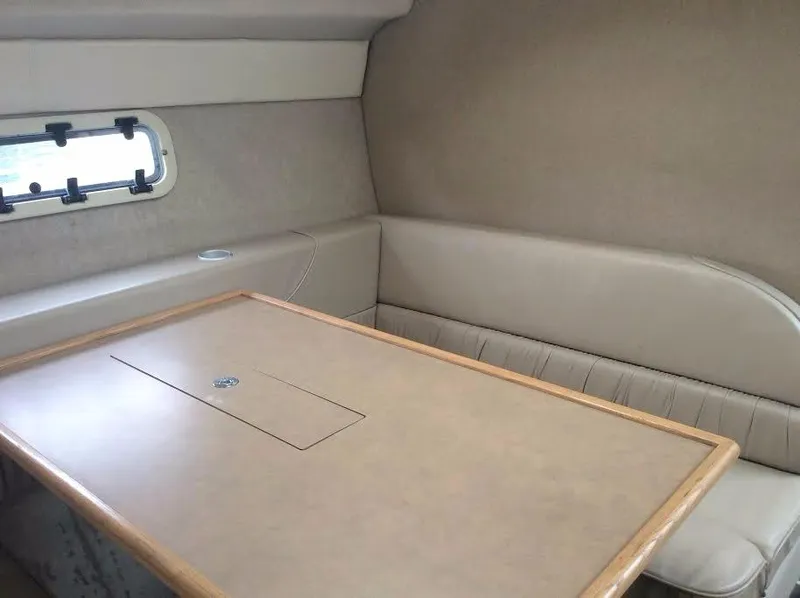Slide: The Image of Interior of 1997 Maxum 3200 SCR boat with beige seating and table. - 10