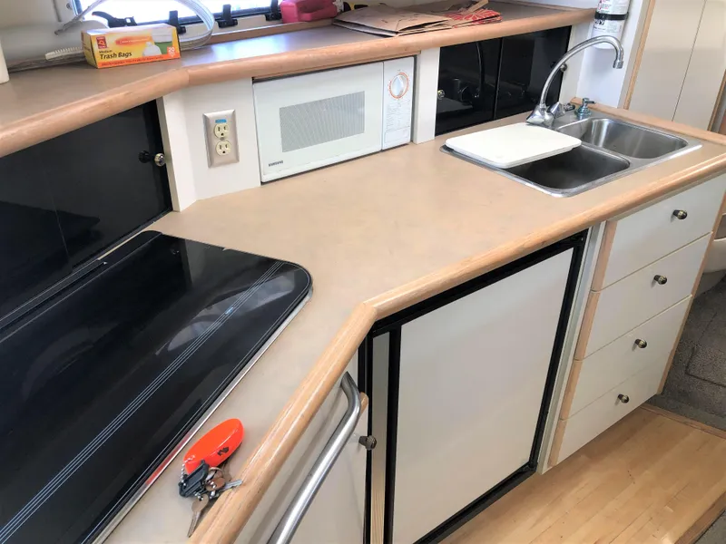 Slide: The Image of 1997 Maxum 3200 SCR boat kitchen with sink, microwave, and stove. - 11