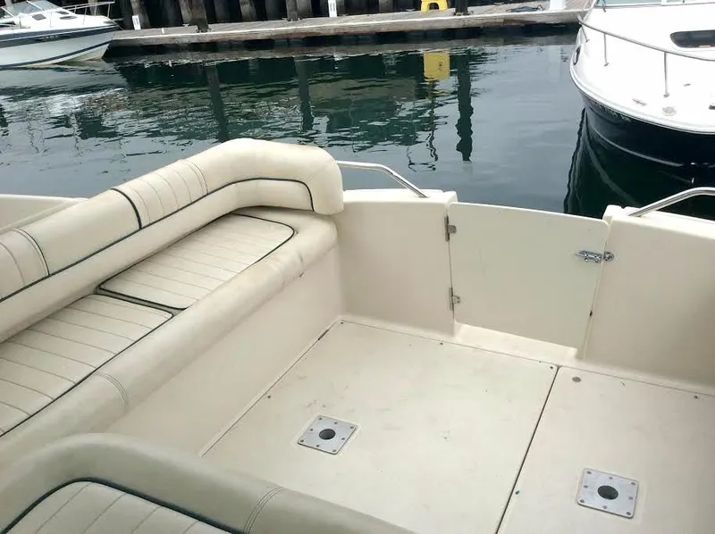 Slide: The Image of 1997 Maxum 3200 SCR boat interior with beige seating at a marina. - 16