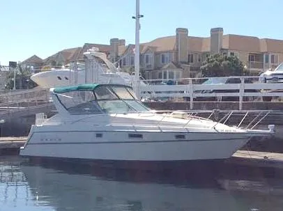 Slide: The Image of 1997 Maxum 3200 SCR boat docked at marina with waterfront homes in background. - 2