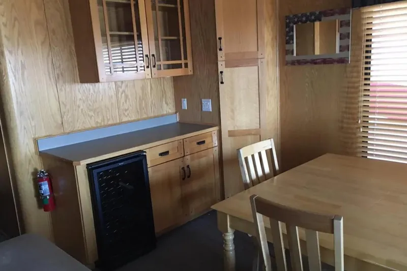 Slide: The Image of Wooden interior of 2005 Sumerset Star Chaser, featuring dining area and cabinetry. - 16