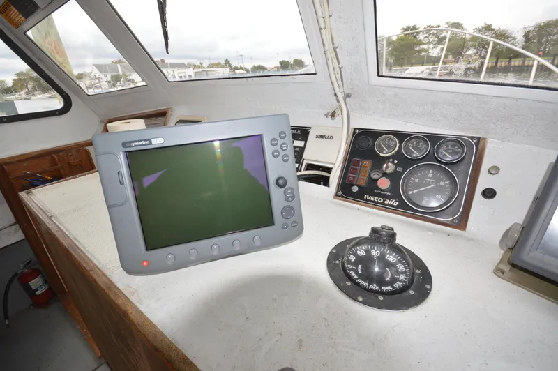 Slide: The Image of 1978 JC 31 boat cockpit with navigation equipment and compass. - 14
