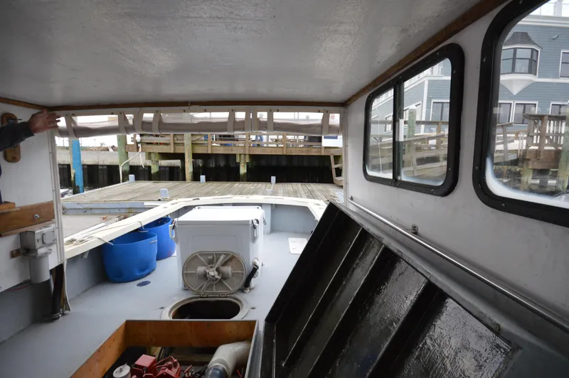 Slide: The Image of Interior view of a 1978 JC 31 boat docked, showing equipment and storage areas. - 19