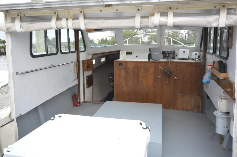 Slide: The Image of 1978 JC 31 boat interior with wooden helm, windows, and equipment. - 22