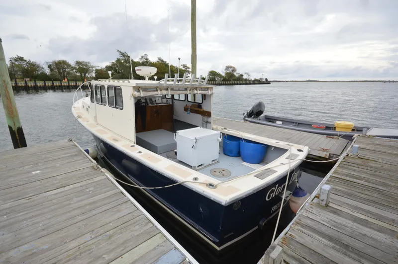 Slide: The Image of 1978 JC 31 boat docked, featuring a spacious deck and classic design. - 4