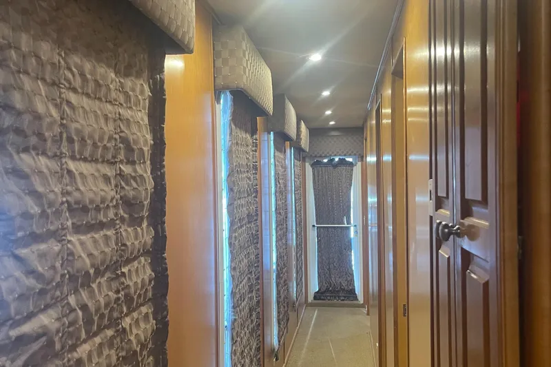 Slide: The Image of Narrow hallway inside a 2003 Sharpe Wailea Trip houseboat, featuring wood paneling and textured walls. - 15