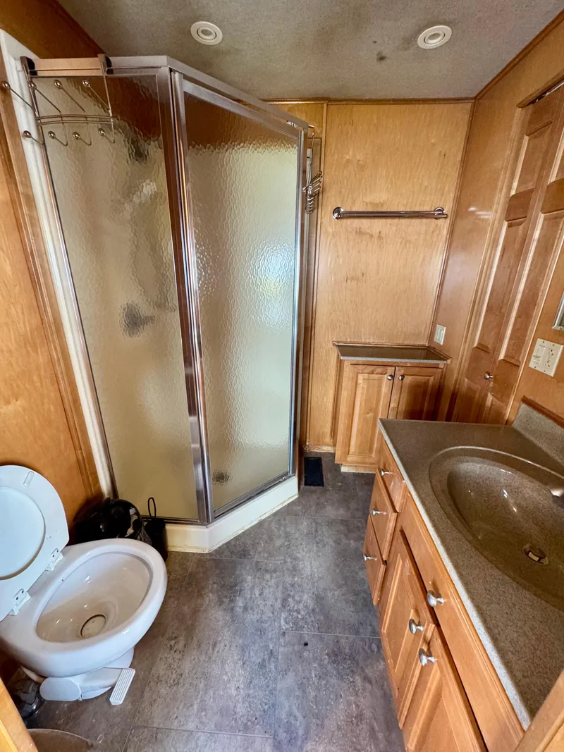 Slide: The Image of Compact bathroom with shower, toilet, and wooden cabinetry in a 2003 Sharpe Wailea Trip model. - 22