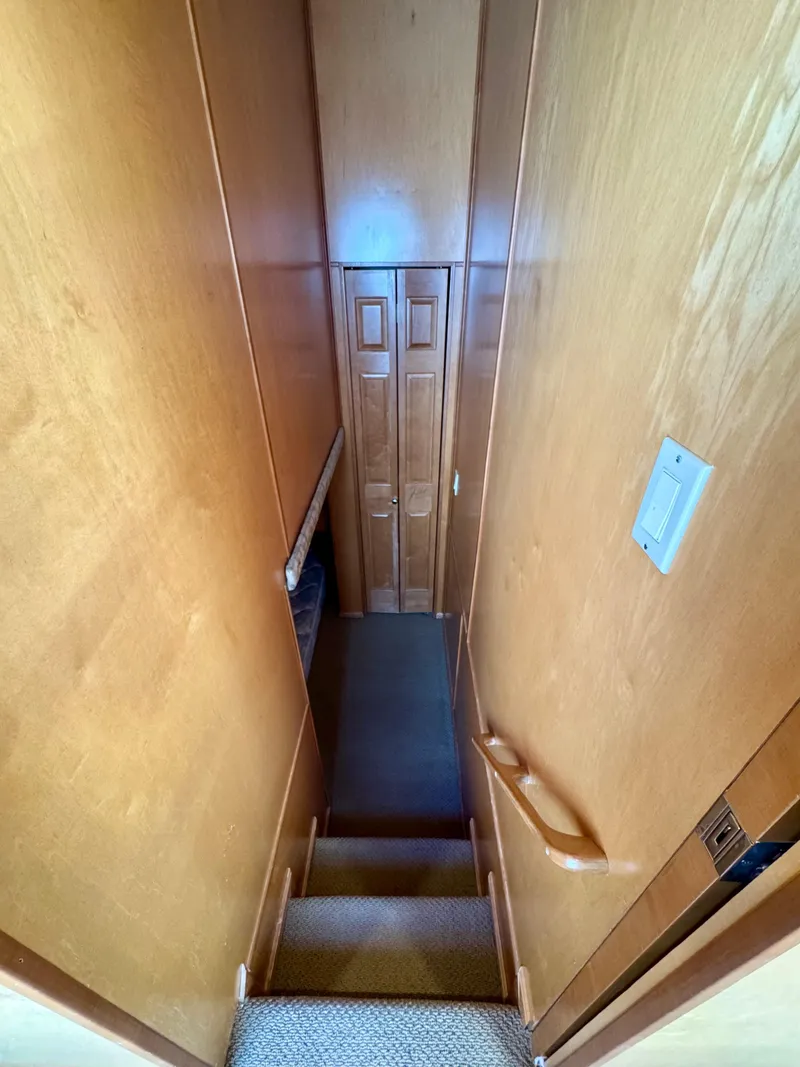 Slide: The Image of Narrow wooden staircase inside 2003 Sharpe Wailea Trip houseboat, featuring light wood paneling. - 23