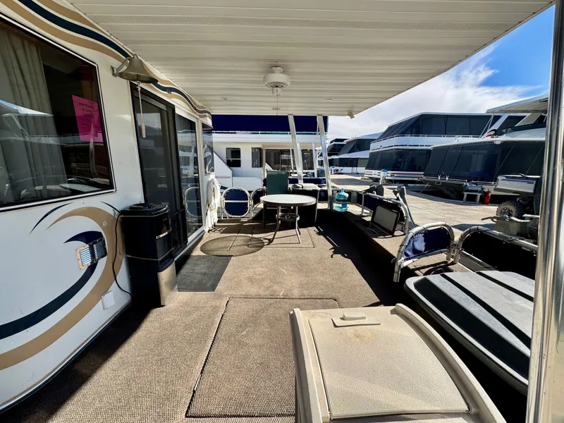 Slide: The Image of Houseboat deck with seating area, 2003 Sharpe Wailea Trip model, docked alongside other boats. - 7