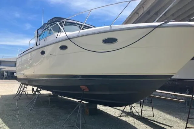 Slide: The Image of 1995 Tiara Yachts 3500 Express boat on stands, under a clear blue sky. - 42