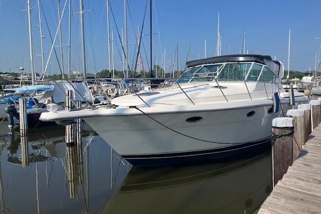 Slide: The Image of 1995 Tiara Yachts Express 3500 docked at a marina under clear blue skies. - 6