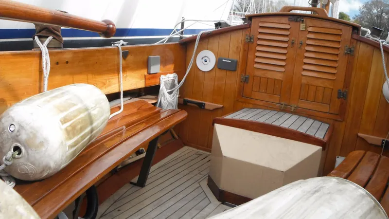 Slide: The Image of Wooden interior of a 1987 Chip Stulen Faering Design 20 boat, featuring benches and nautical equipment. - 16