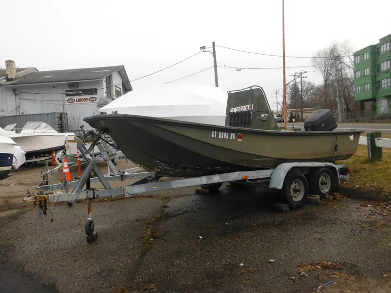 The Image of 1977 McKee Craft 17S boat on a trailer in a parking lot. - 0