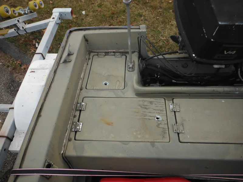 Slide: The Image of 1977 McKee Craft 17S boat stern with storage compartments and outboard motor. - 17