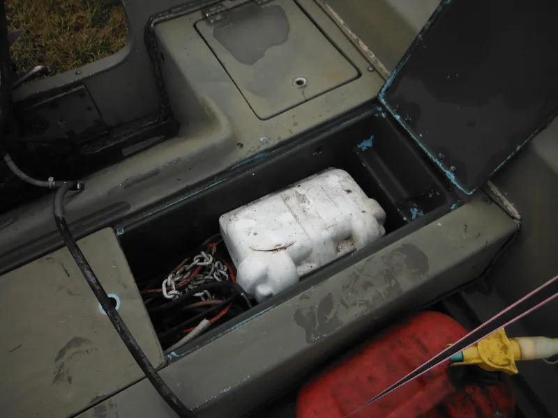 Slide: The Image of 1977 McKee Craft 17S boat storage compartment with battery and wiring. - 21
