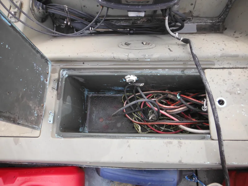 Slide: The Image of Open storage compartment with tangled wires on a 1977 McKee Craft 17S boat. - 22