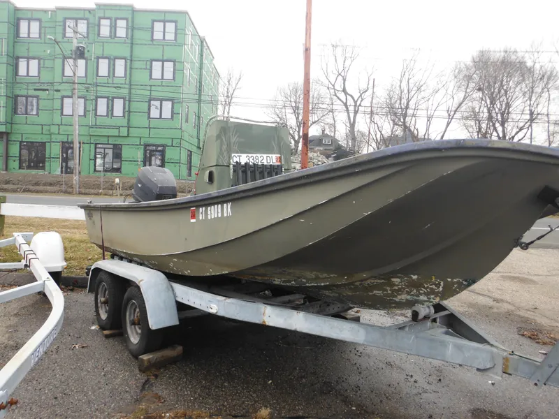Slide: The Image of 1977 McKee Craft 17S boat on a trailer in an urban area. - 30