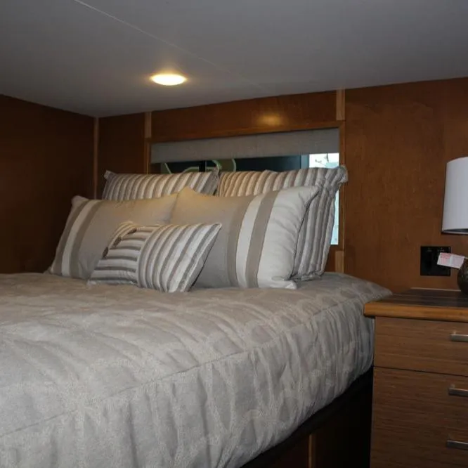 Slide: The Image of Cozy bedroom in 2015 Bravada Evolution Share #7 with striped pillows and wooden accents. - 8