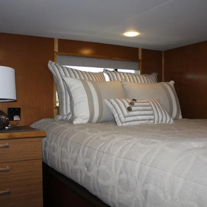 Slide: The Image of Cozy bedroom in 2015 Bravada Evolution Share #7 houseboat with striped pillows and wooden accents. - 9