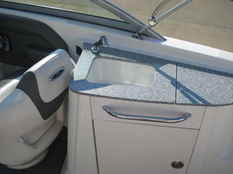 Slide: The Image of 2015 Chaparral 244 Sunesta boat interior with sink and seating area. - 10