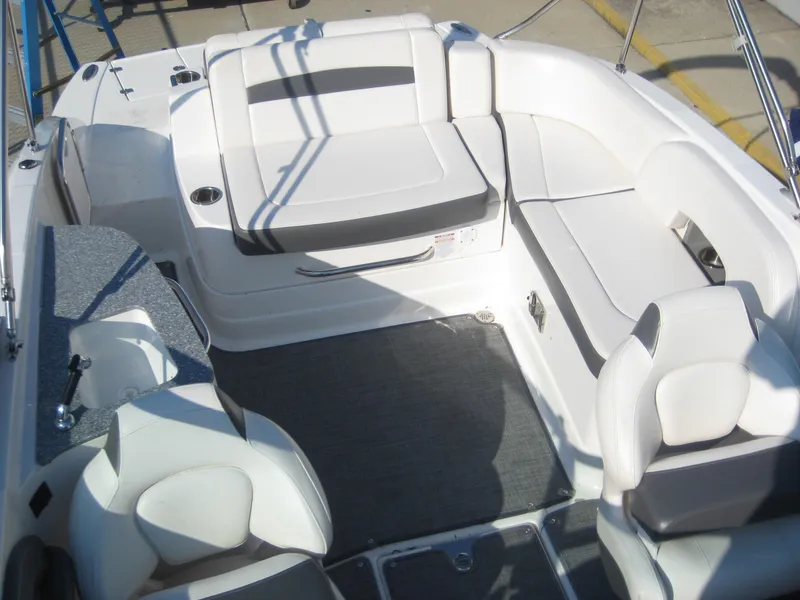 Slide: The Image of 2015 Chaparral 244 Sunesta boat interior with white seating and gray flooring. - 13