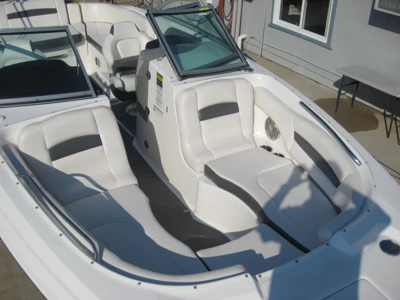 Slide: The Image of 2015 Chaparral 244 Sunesta boat interior with white seating and open cockpit design. - 7