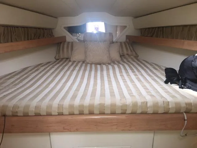 Slide: The Image of Interior of a 2002 Fountain 38 Express Cruiser with striped bedding. - 26