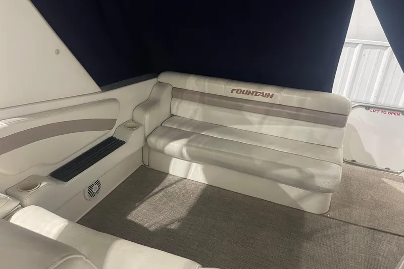 Slide: The Image of Interior seating of 2002 Fountain 38 Express Cruiser with white upholstery and cup holders. - 6