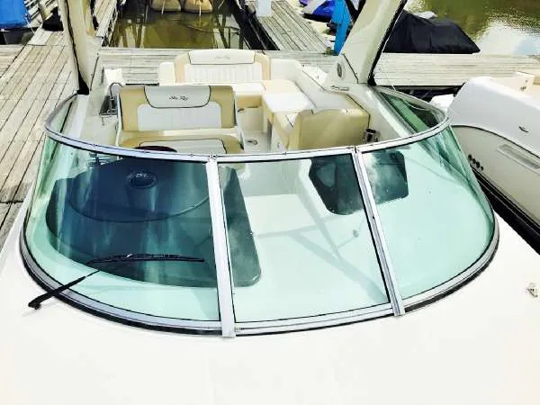 Slide: The Image of 2013 Sea Ray 310 Sundancer boat with spacious seating and sleek design at a dock. - 10