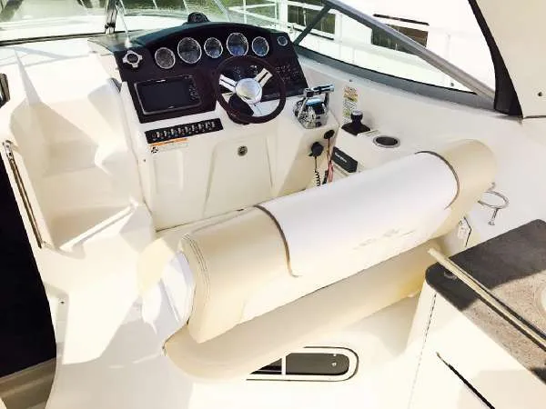Slide: The Image of 2013 Sea Ray 310 Sundancer helm with steering wheel and control panel. - 14