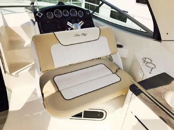 Slide: The Image of 2013 Sea Ray 310 Sundancer helm with beige and white seating, steering wheel, and dashboard. - 15