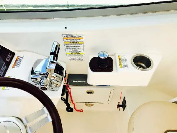 Slide: The Image of 2013 Sea Ray 310 Sundancer helm with controls and cup holder. - 18