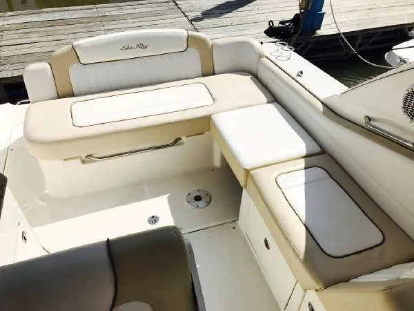 Slide: The Image of 2013 Sea Ray 310 Sundancer boat interior with beige seating and storage compartments. - 26