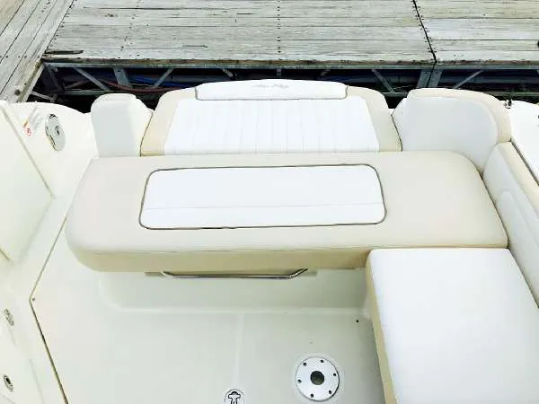 Slide: The Image of 2013 Sea Ray 310 Sundancer boat seating area with white and beige upholstery. - 28
