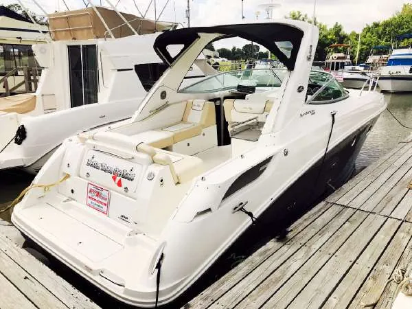 Slide: The Image of 2013 Sea Ray 310 Sundancer docked, showcasing sleek design and spacious seating. - 3