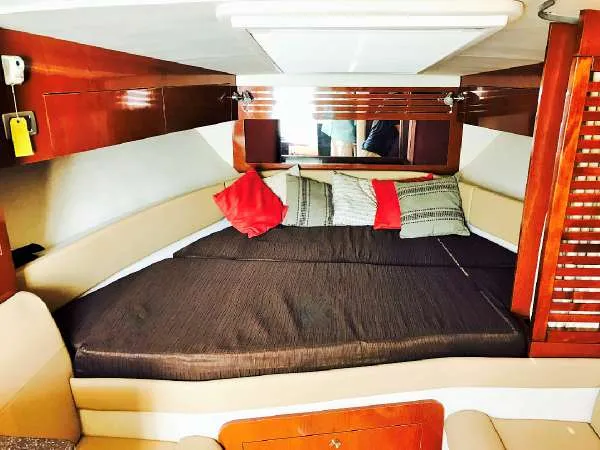 Slide: The Image of 2013 Sea Ray 310 Sundancer cabin with cozy bed and decorative pillows. - 30