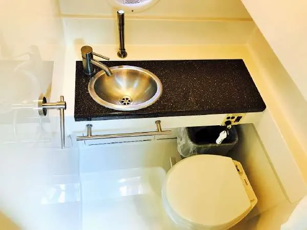 Slide: The Image of 2013 Sea Ray 310 Sundancer bathroom with sink and toilet, featuring modern design. - 34