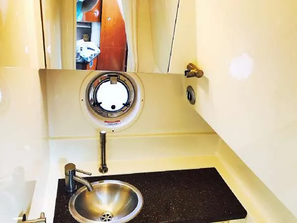 Slide: The Image of 2013 Sea Ray 310 Sundancer bathroom with sink and porthole window. - 35