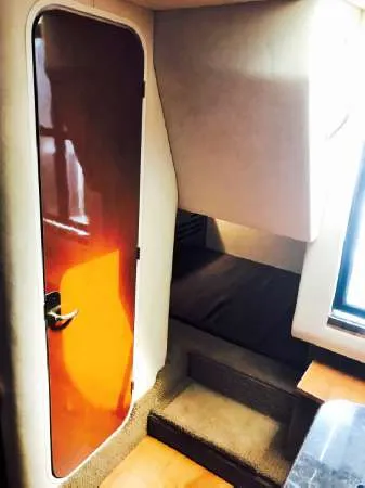 Slide: The Image of 2013 Sea Ray 310 Sundancer cabin interior with wooden door and carpeted steps. - 39