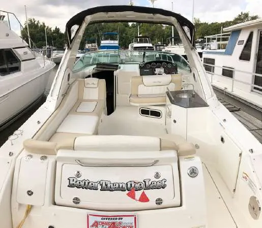 Slide: The Image of 2013 Sea Ray 310 Sundancer boat interior at marina, featuring seating and helm. - 5