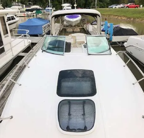 Slide: The Image of 2013 Sea Ray 310 Sundancer docked, showcasing sleek design and spacious deck. - 6