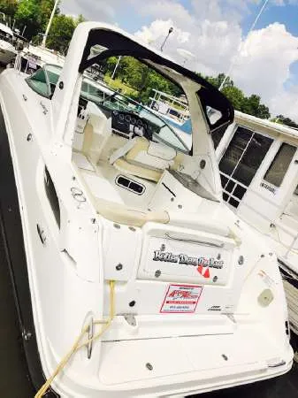 Slide: The Image of 2013 Sea Ray 310 Sundancer boat docked, featuring a sleek white design and spacious cockpit. - 7