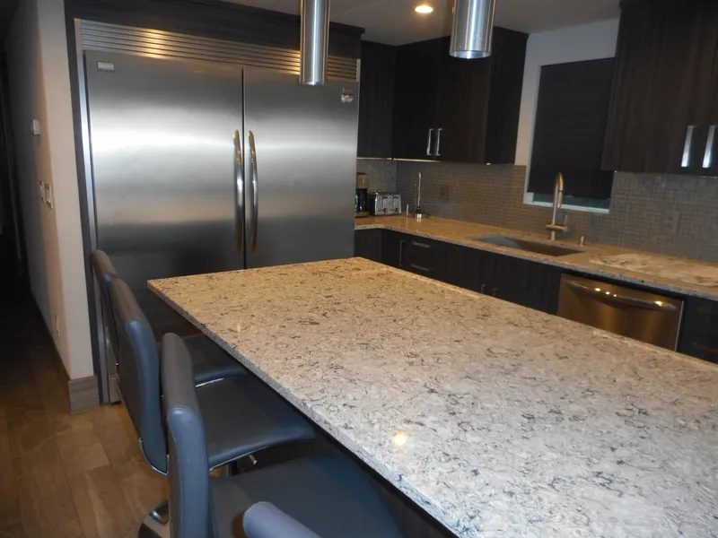 Slide: The Image of Modern kitchen with granite island, stainless steel appliances, and dark cabinetry. Adonia Liquidity Trip 5, 2017. - 27
