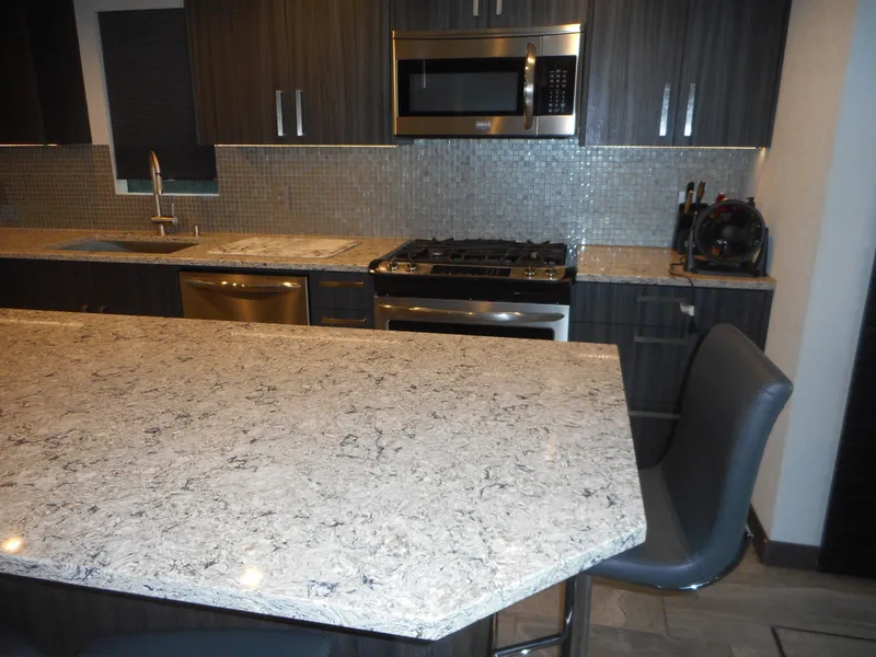 Slide: The Image of Modern kitchen with granite countertops, stainless steel appliances, and dark wood cabinets. - 28