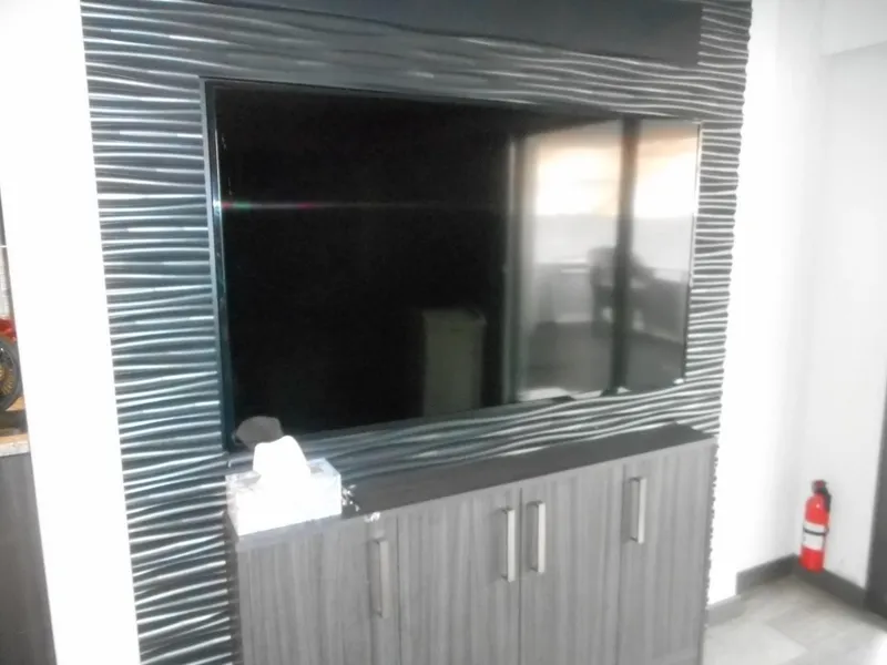 Slide: The Image of Modern entertainment unit with sleek black TV and striped paneling, featuring Adonia Liquidity Trip 5. - 30